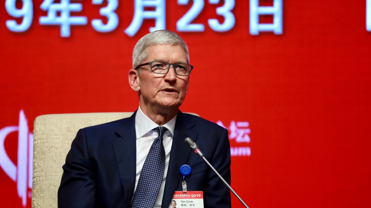 Apple CEO Tim Cook speaking at a conference in China on March 23, 2019, with a red background displaying the date in Chinese characters