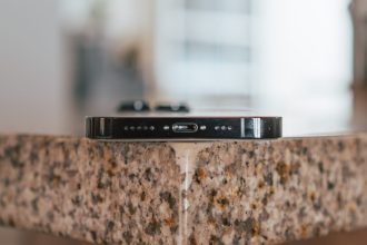 Close-up of an iPhone resting on a countertop, showcasing the device’s charging port and speaker grills