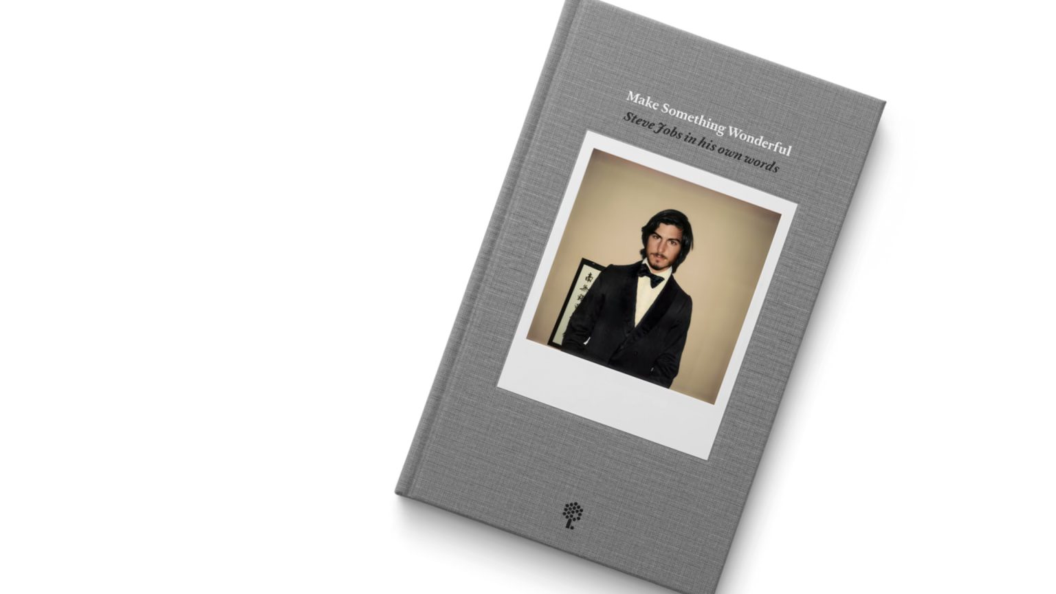 Grey fabric book cover on a white backgroud bearing the words "Make Something Wonderful, Steve Jobs in his own words" with a polaroid photograph of Steve Jobs in a suit and bow tie in his mid twenties